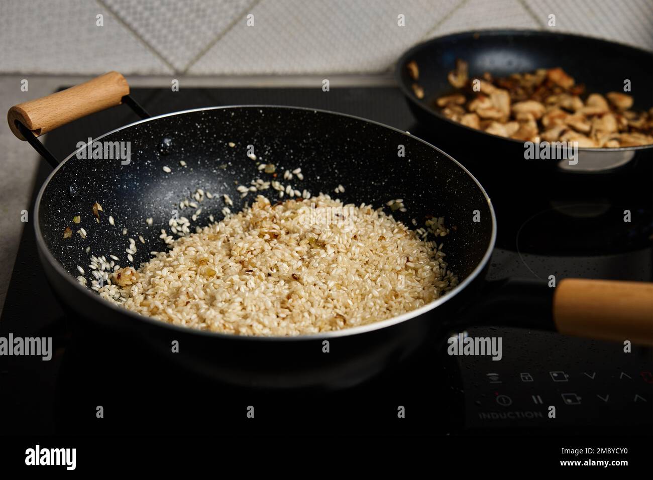 Proceso de cocción del risotto. Arroz arborio en sartén en la cocina