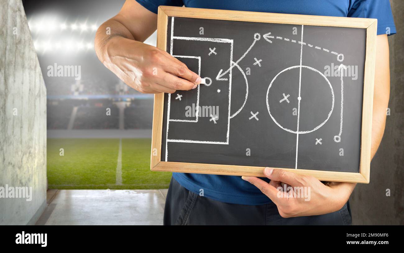 mano de un entrenador de fútbol dibujando una táctica de juego de fútbol  con tiza blanca en pizarra en el túnel de arena Fotografía de stock - Alamy