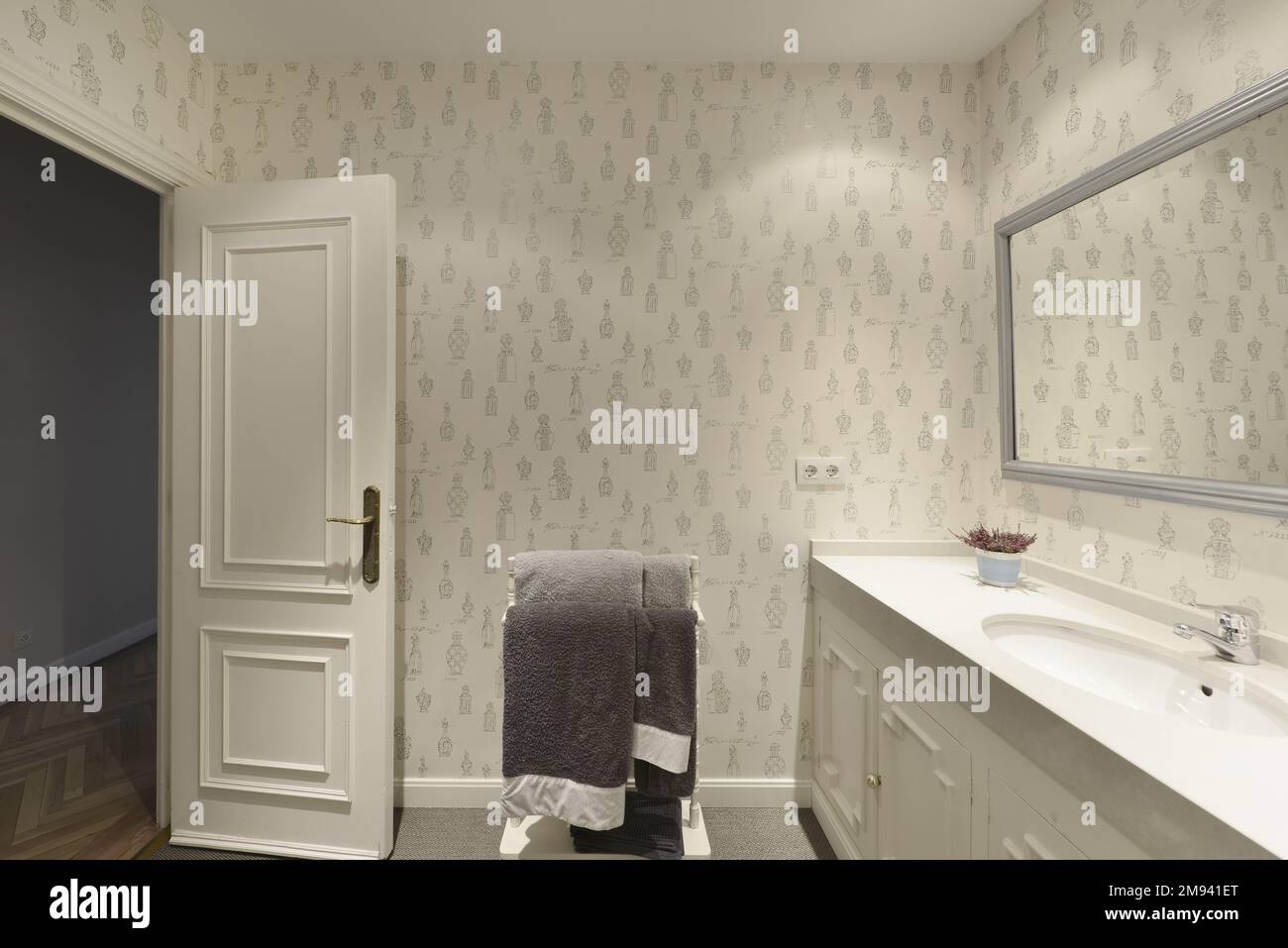 Cuarto de baño fregadero de madera con una de una pieza y lavabo un espejo enmarcado gris y paredes empapeladas Fotografía de stock - Alamy
