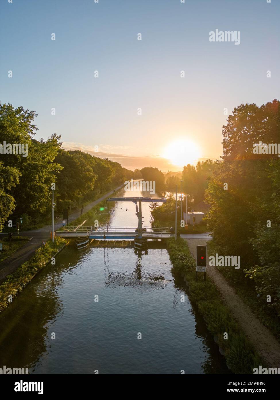 Vista aérea de un espectacular y colorido cielo al amanecer sobre un canal con un puente en Bélgica. Canales con agua para transporte, agricultura. Campos y prados. Paisaje. Fotografía de alta calidad Foto de stock