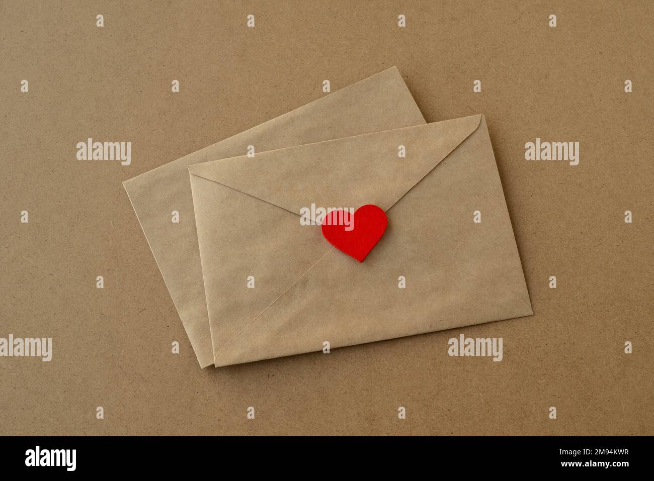 Día de San Valentín. Sobres de cartas de amor y corazón rojo sobre un fondo  de papel kraft. Tarjeta de San Valentín Fotografía de stock - Alamy