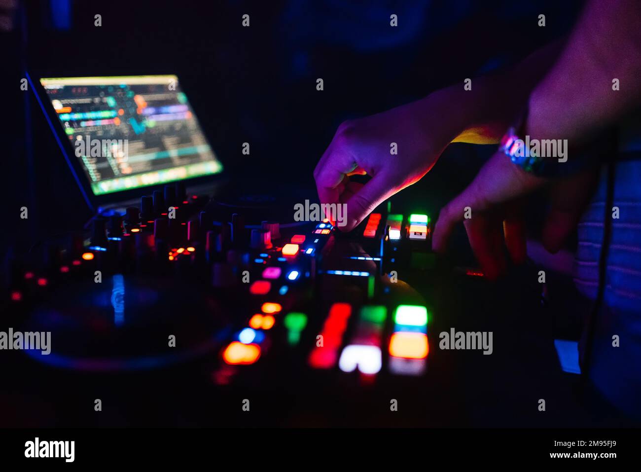 Manos de un DJ profesional tocando y mezclando música para una fiesta de sueño y los controladores de torque de la consola Foto de stock
