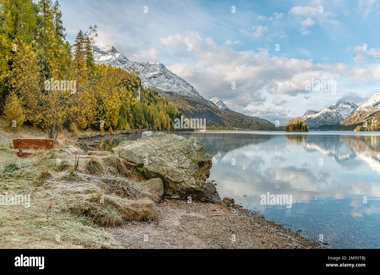 Banco del parque en un paisaje de otoño en el lago Sils, Engadine, Suiza con Piz Margna en el fondo Foto de stock