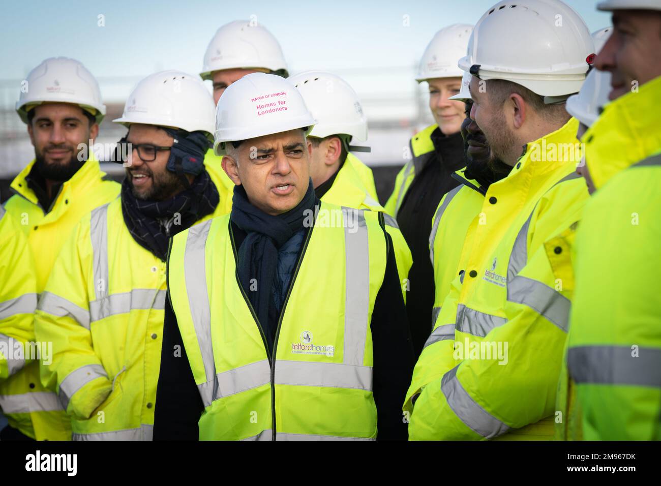 El alcalde de Londres, Sadiq Khan (centro), durante la ceremonia de finalización de un nuevo desarrollo de viviendas asequibles en el Royal Docks, al este de Londres, donde anunció que se han completado más casas nuevas bajo él que bajo cualquier alcalde anterior de Londres. Fecha de la fotografía: Martes 17 de enero de 2023. Foto de stock