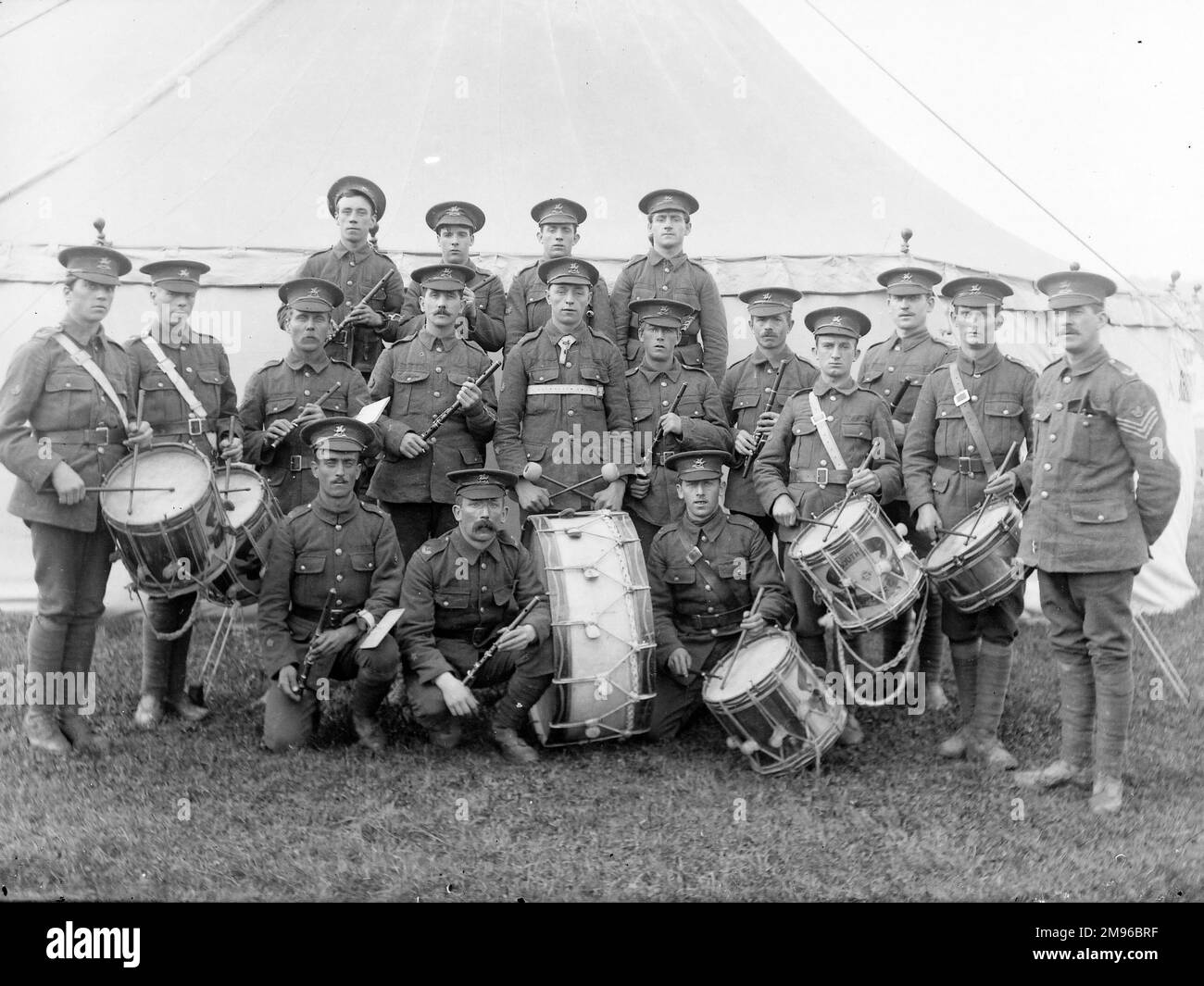 Una banda militar, los Brecknockshire Battalion South Wales Borderers, junto con sus instrumentos, incluyendo seis tambores, posando para su foto frente a una tienda de campaña. Foto de stock