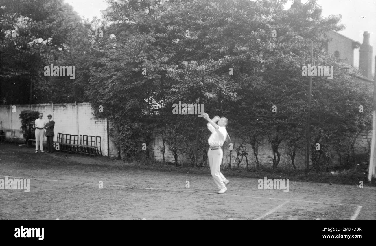 Torneo de tenis eduardiano que muestra a un hombre sirviendo en un partido en el área de Stockport - la velocidad de obturación debe haber sido excelente para el tiempo, ya que la pelota es capturada en vuelo Foto de stock