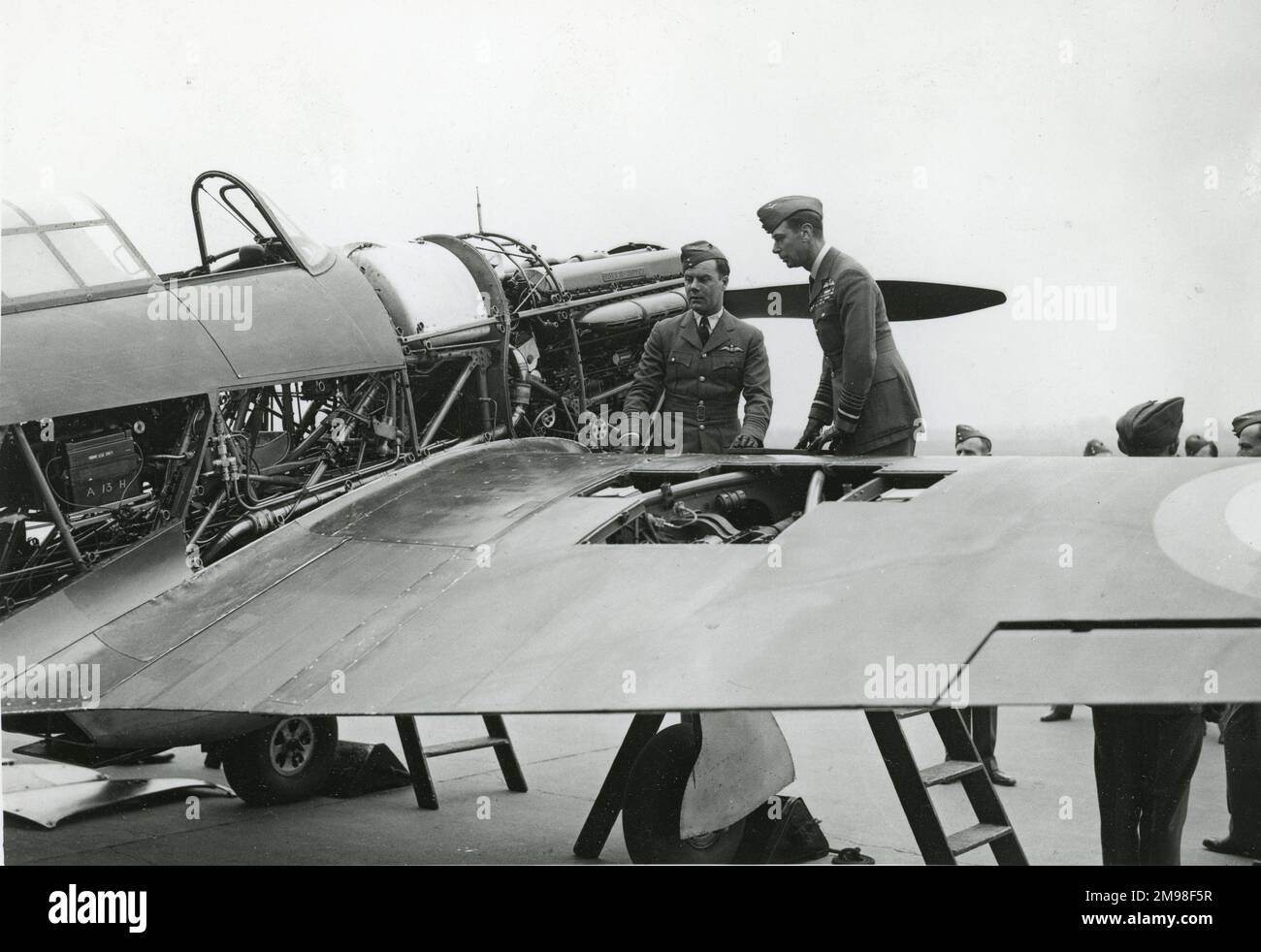 El Rey Jorge VI felicitó al Dr. John Woodburn Gillan e inspeccionó el Huracán Hawker en el que realizó un vuelo récord desde Londres a Edimburgo el 11 de febrero de 1938. La fotografía fue presentada a la Sociedad por la Sra. Gillan, la madre del piloto, en agosto de 1944. Foto de stock