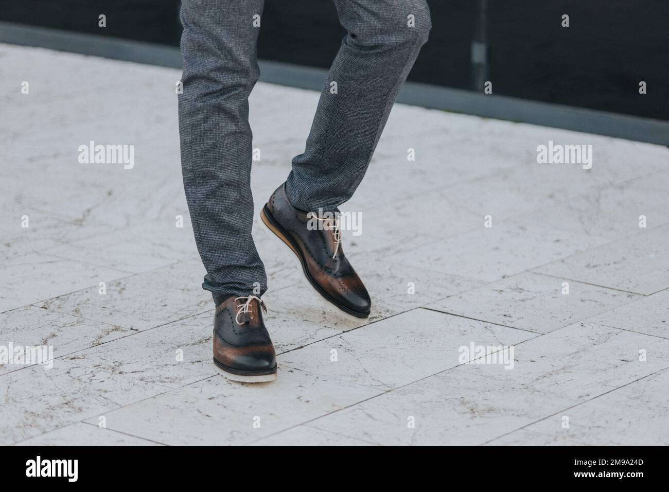manipular Exactitud Puntualidad Un hombre con estilo en pantalones de traje gris texturizado y zapatos  brogue oscuros Fotografía de stock - Alamy