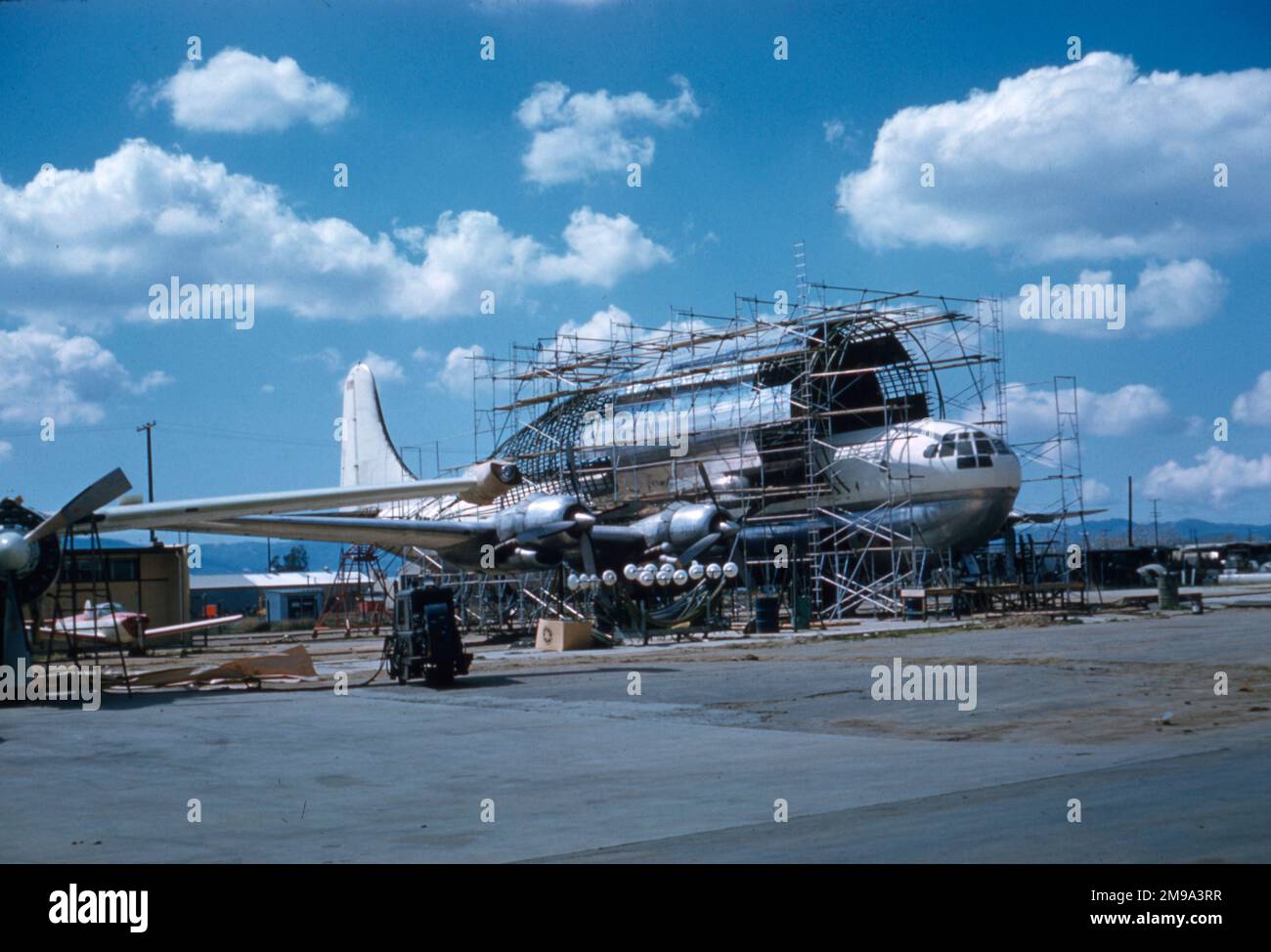 Embarazada Guppy N1024V en construcción con On Mark Engineering en LAX - Marzo 1962. La conversión se llevó a cabo en etapas, primero se insertó una parte de BOAC Stratocruiser en el fuselaje trasero y luego se agregó la gran carcasa exterior del compartimiento de carga al fuselaje estándar B337, para pruebas aerodinámicas y estructurales. Después de que el avión voló con éxito y se demostró a Wernher von Braun, se generó suficiente interés para completar la conversión cortando el fuselaje estándar dentro de la gran carcasa. - (Fotógrafo - AR Krieger) Foto de stock