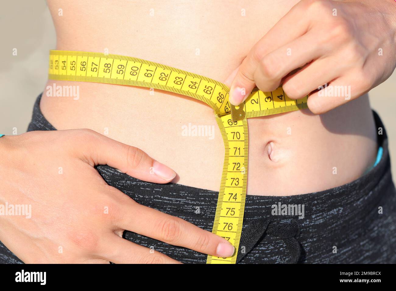 medida de la cintura del vientre de la muchacha joven con la cinta métrica  y medida en centímetros Fotografía de stock - Alamy