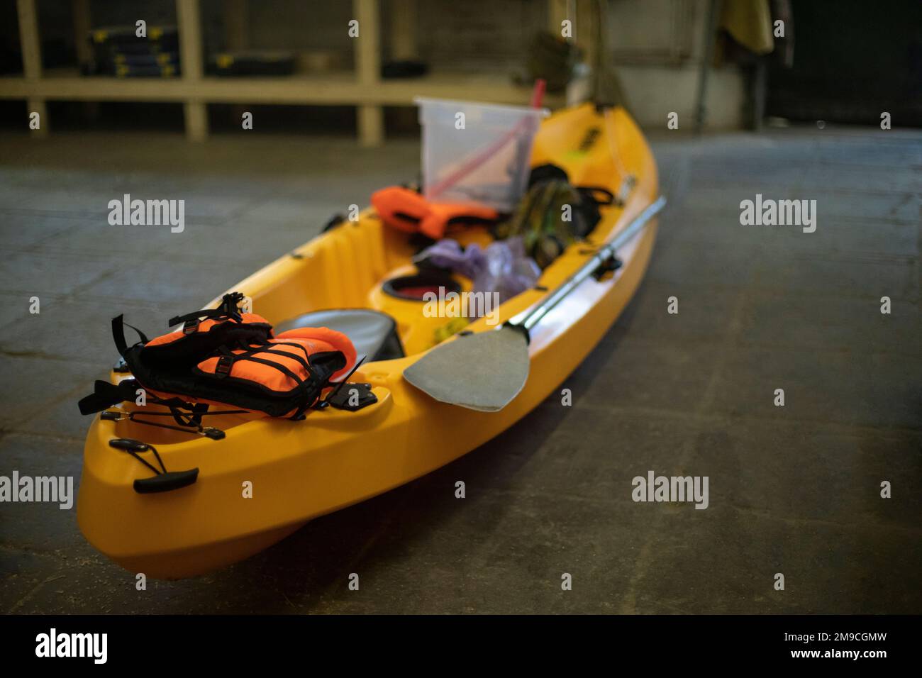 Barco amarillo hecho de plástico. Canoa en garaje. Equipamiento deportivo. Foto de stock