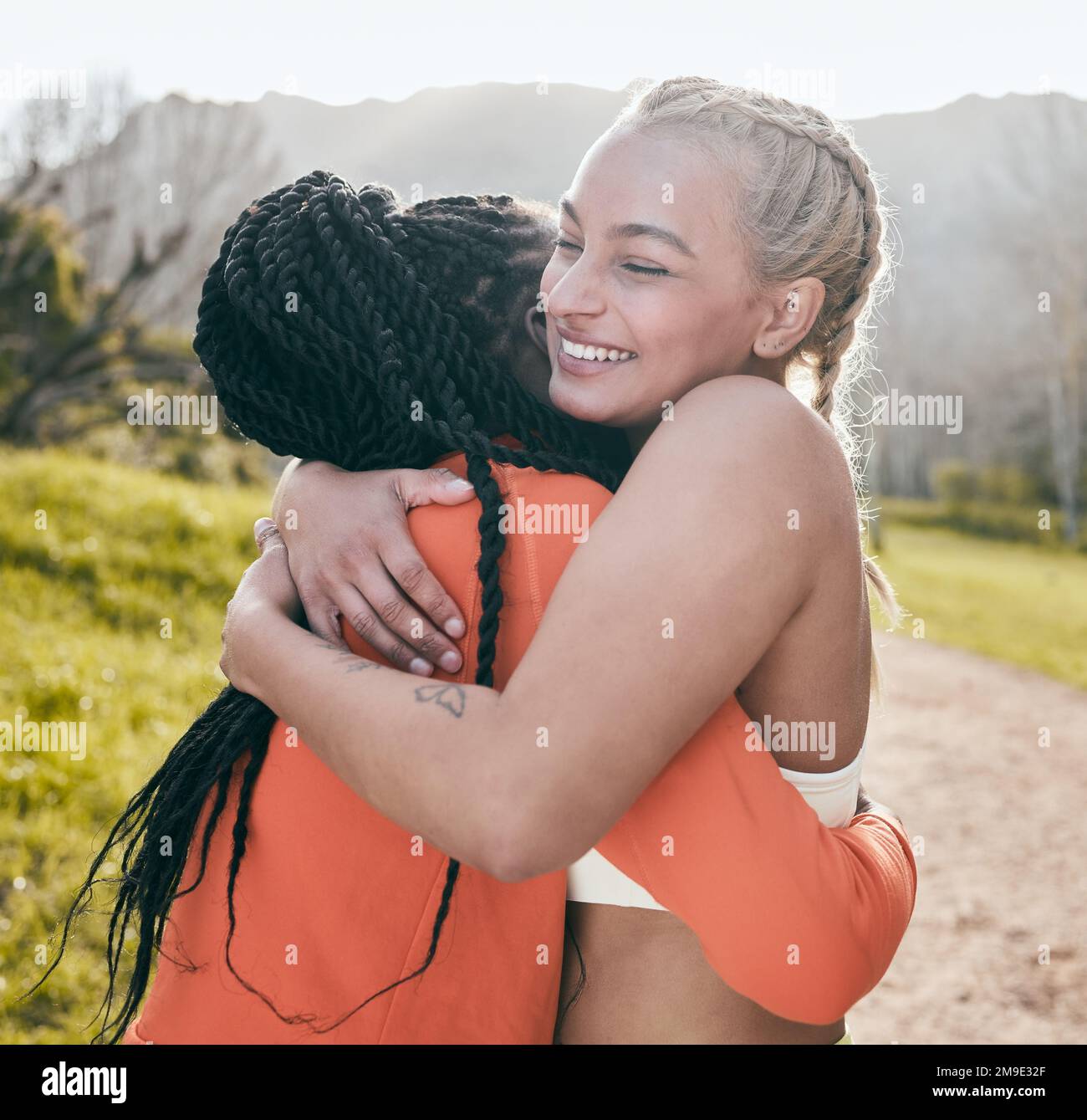 Estoy tan orgulloso de ti por lograr tu objetivo. una mujer joven atractiva de pie y abrazando a su amigo durante su entrenamiento al aire libre. Foto de stock