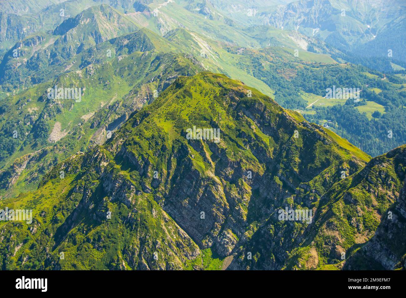 Vista desde una altura en las laderas de las montañas de la cresta del paso cubierta de vegetación, un hermoso paisaje natural Foto de stock