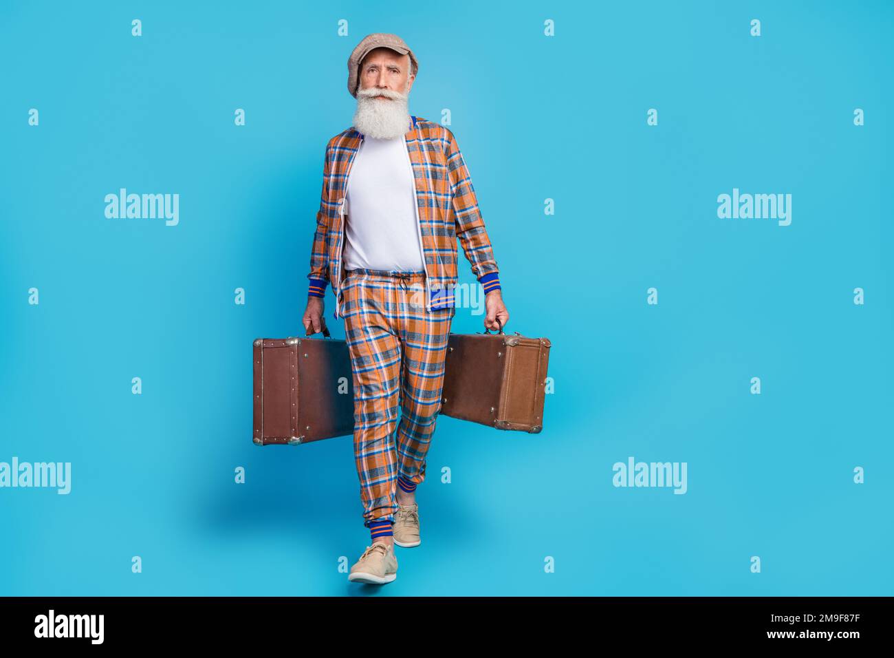 Foto de cuerpo completo de hombre jubilado confiado serio vestido traje de  cuadros sosteniendo maletas vintage espacio vacío aislado fondo de color  azul Fotografía de stock - Alamy