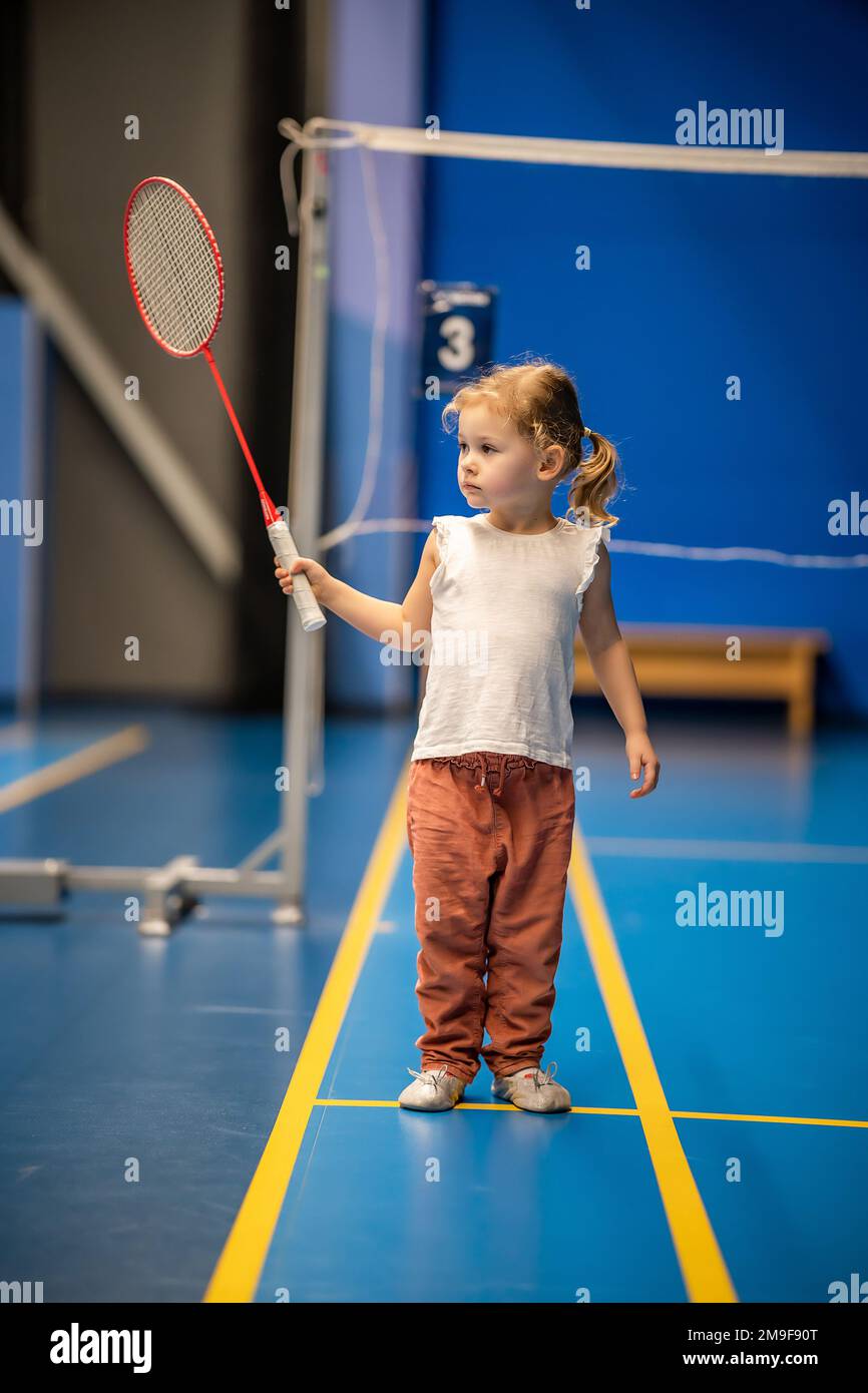 Ni a de tres a os jugando b dminton en ropa deportiva en la cancha