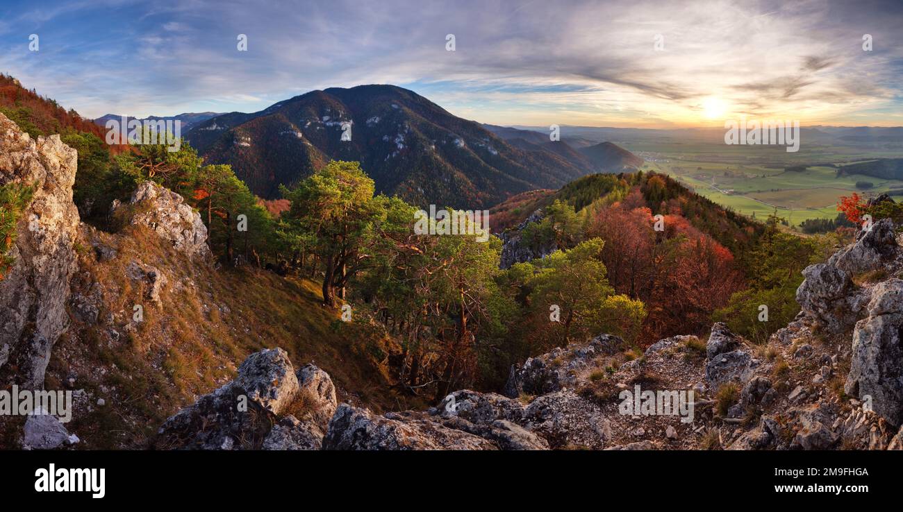 Panorama de montañas. Todo iluminado luz amarilla del sol. el cielo hermosas nubes rojas Foto de stock