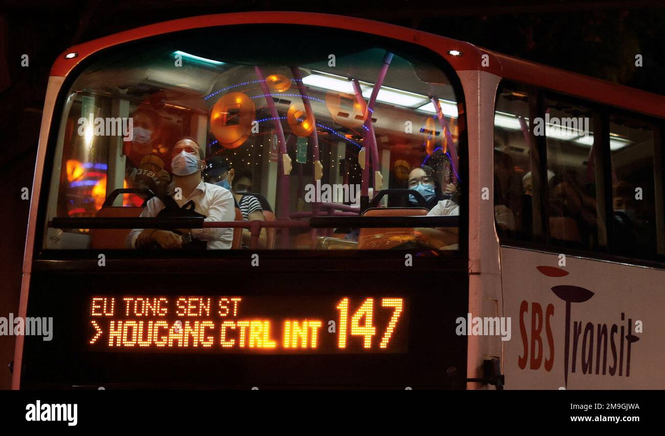 Los viajeros miran las decoraciones del festival desde la cubierta superior de un autobús en Chinatown antes del Año Nuevo Lunar en Singapur el 18 de enero de 2023. REUTERS/Edgar Su Foto de stock