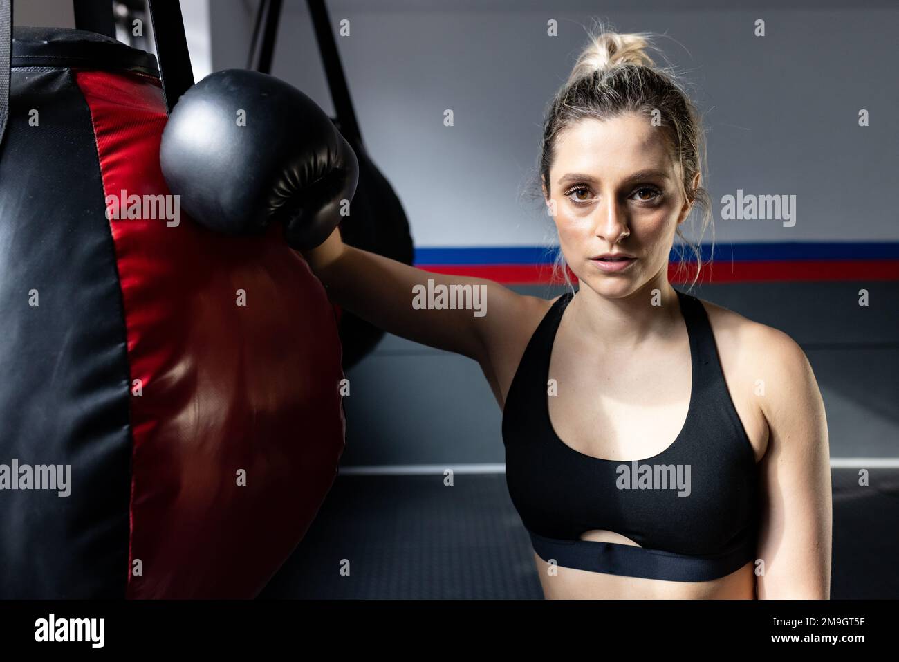 Retrato de la mujer caucásica en forma con el bolso de boxeo en el  gimnasio. Concepto global de deporte, salud y estilo de vida Fotografía de  stock - Alamy