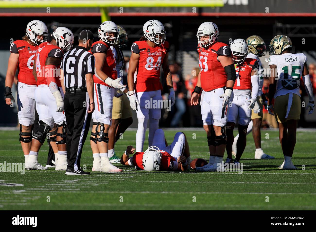 Cincinnati quarterback Ben Bryant, bottom, lies on the field after