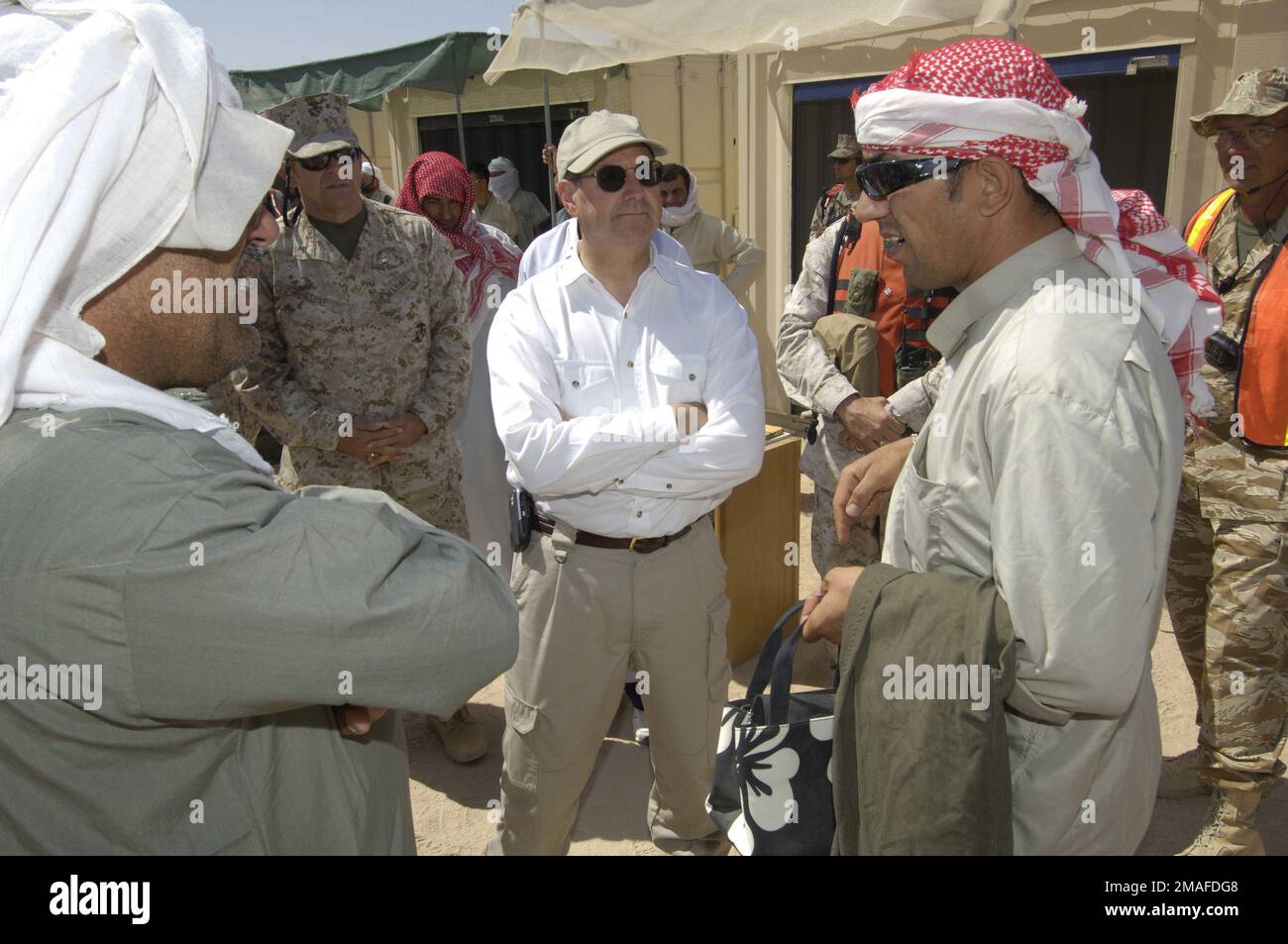 060509-N-2568S-139. [Completo] Texto de la escena: El Honorable Dr. Donald C. Winter (camisa blanca), el Secretario de la Marina (SECNAV) y el General de Brigada del Cuerpo de Marines de los EE. UU. (USMC), Comando de Entrenamiento de la Fuerza de Tarea Aérea Terrestre de la Marina (MAGTF), habla con estadounidenses-iraquíes que manejan el simulado Souq, un mercado iraquí, durante el ejercicio MOJAVE VIPER. Quieren hacer su parte en la preparación de los marines de USMC para las diversas situaciones que pueden encontrar mientras están en Irak. MOJAVE VIPER simula una aldea iraquí, dando a los marines de USMC la oportunidad de echar un vistazo temprano a algunos de los potencialmente Foto de stock