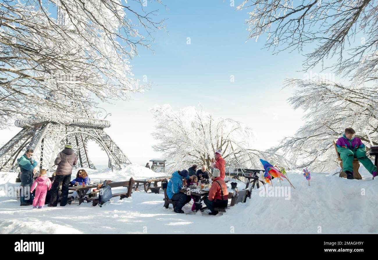 Las familias disfrutan de su almuerzo al aire libre en la nieve, Monte Amiata, Toscana, Italia Foto de stock