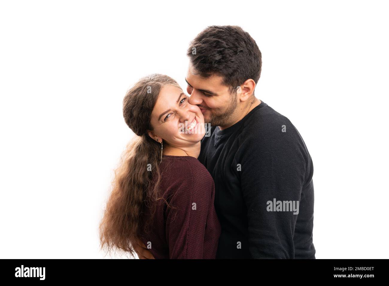 Hombre adulto que besa a la novia de la mujer en la mejilla como pareja  romántica linda que lleva el concepto casual de la ropa del otoño aislado en  el fondo blanco