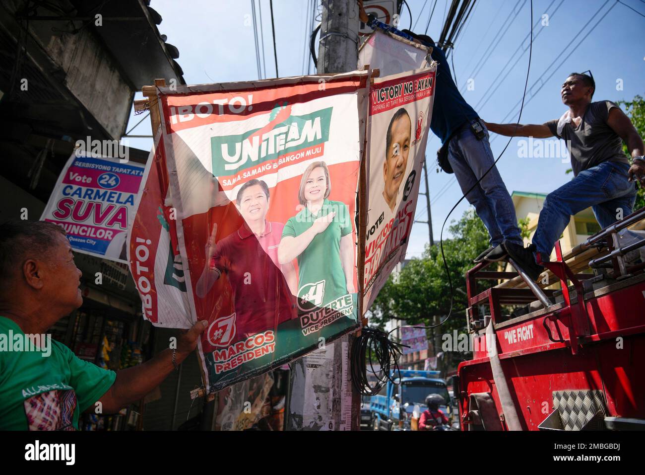 Village workers remove a campaign poster showing Presidential candidate  Ferdinand "Bongbong" Marcos Jr. and running mate Sara Duterte along a  street in Quezon city, Philippines on Wednesday, May 11, 2022. Marcos, the