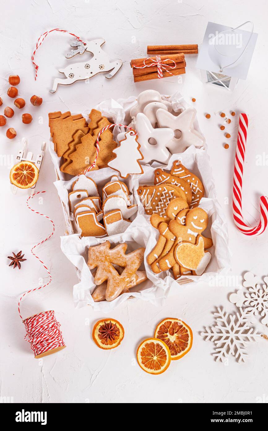 Vista superior del regalo de Navidad desembalado con dulces sobre una superficie texturada blanca, primer plano. Concepto de celebración de Navidad Foto de stock
