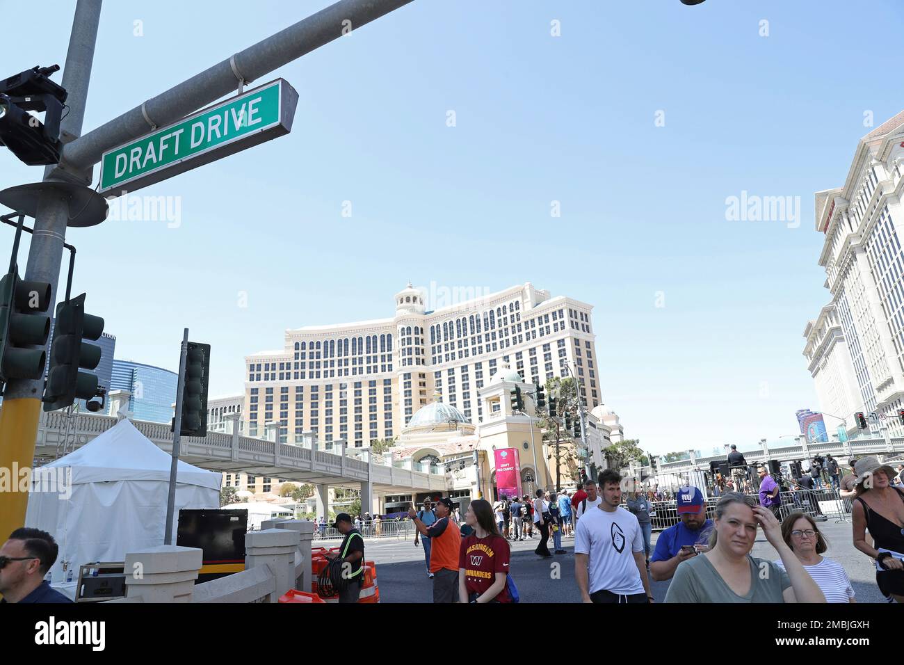 Fans walk underneath a Draft Drive ceremonial street sign on Thursday, April 28, 2022, in Las Vegas. The corner of Las Vegas Blvd. and Flamingo was temporarily renamed for the NFL Draft being held April 28-30. (AP Photo/Gregory Payan) Foto de stock