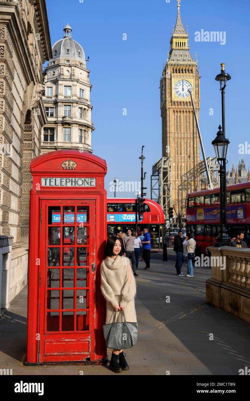 Mujer delante de la caja roja del teléfono, Big Ben en el fondo, Westminster, Londres, Inglaterra, Gran Bretaña, Reino Unido Foto de stock