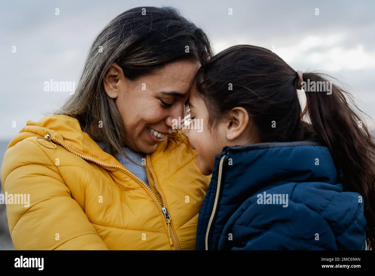 Madre latina feliz con su hija teniendo momento tierno al aire libre - Familia y amor concepto Foto de stock