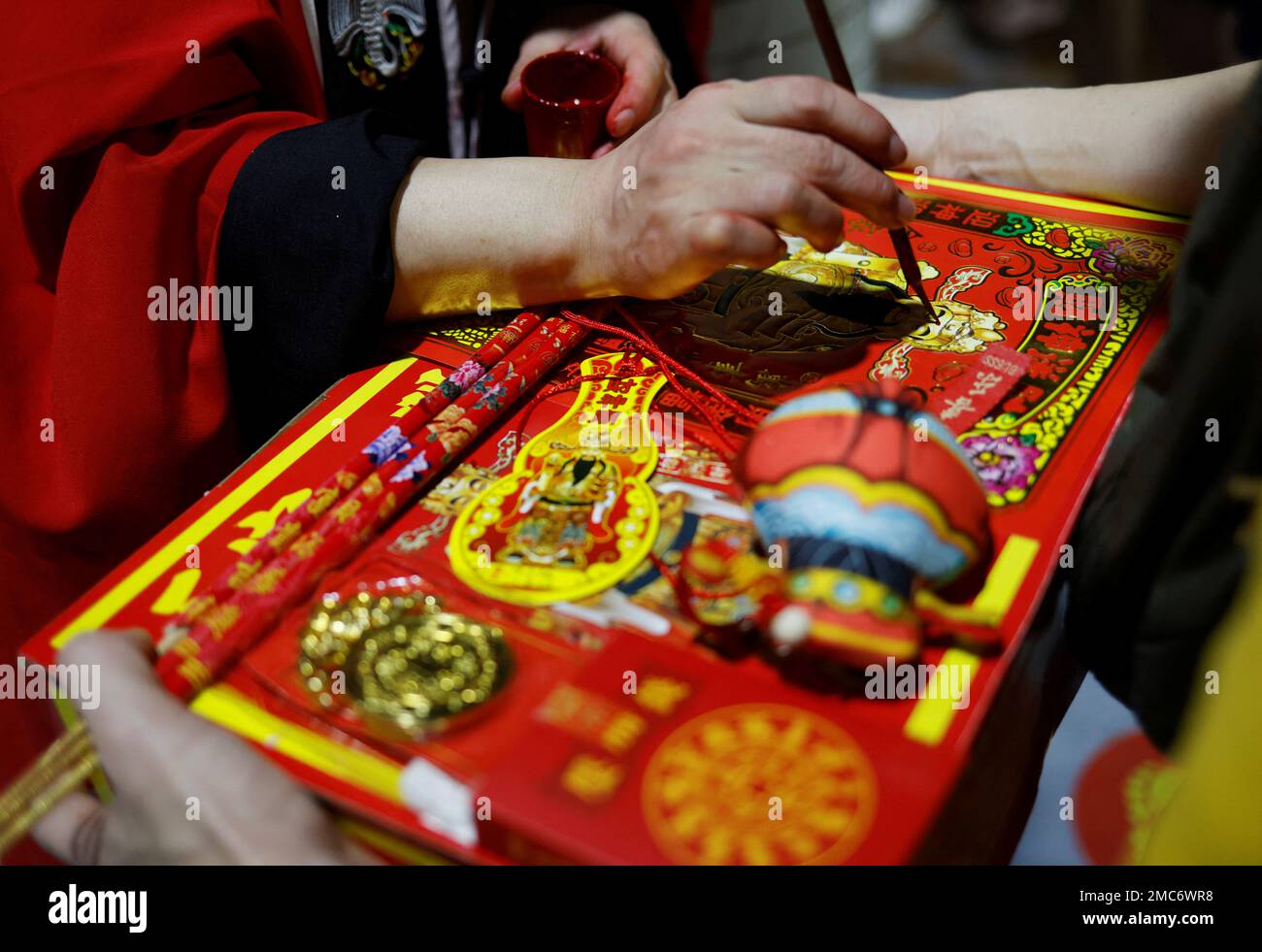 Una sacerdotisa marca las ofrendas de un devoto durante una ceremonia para dar la bienvenida al Dios de la Riqueza en un templo en la víspera del Año Nuevo Lunar en Singapur el 21 de enero de 2023. REUTERS/Edgar Su Foto de stock