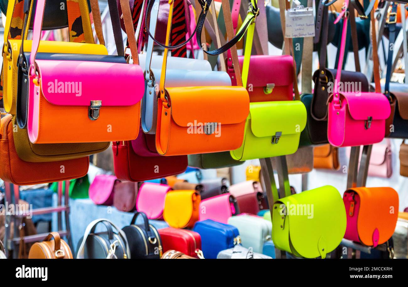 Bolsos de cuero de color neón en A to Z Leather, Spitalfields Market, Londres, Reino Unido Foto de stock