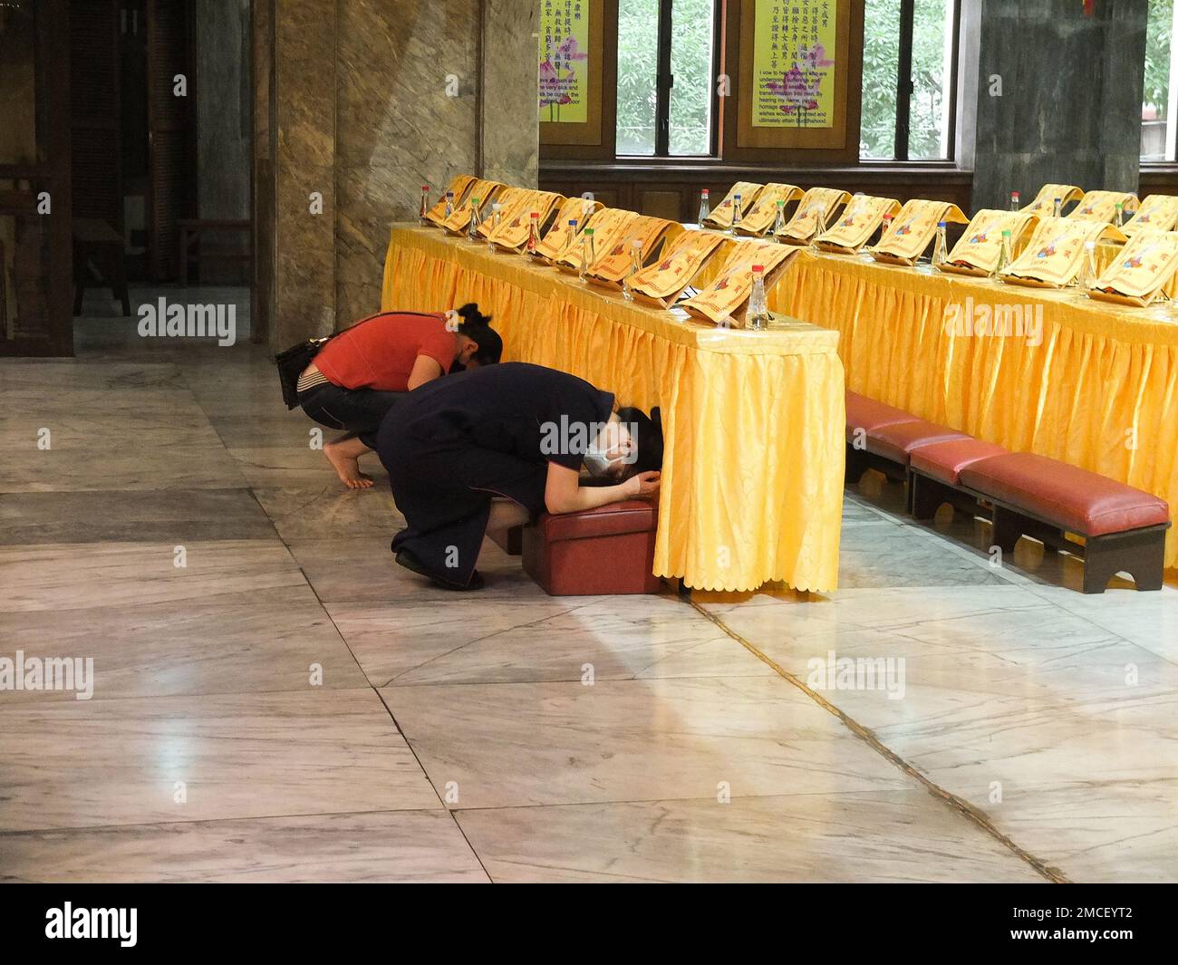 Los adoradores chinos se arrodillan y se inclinan para respetar a Buda