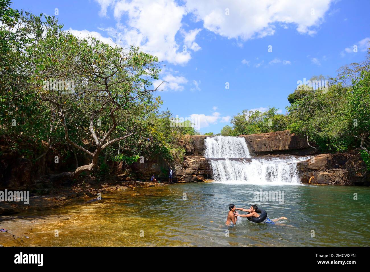 Niños con aros de natación en la cascada Cachoeira da Martinha, NP Chapada dos Guimaraes, Mato Grosso, Brasil Foto de stock