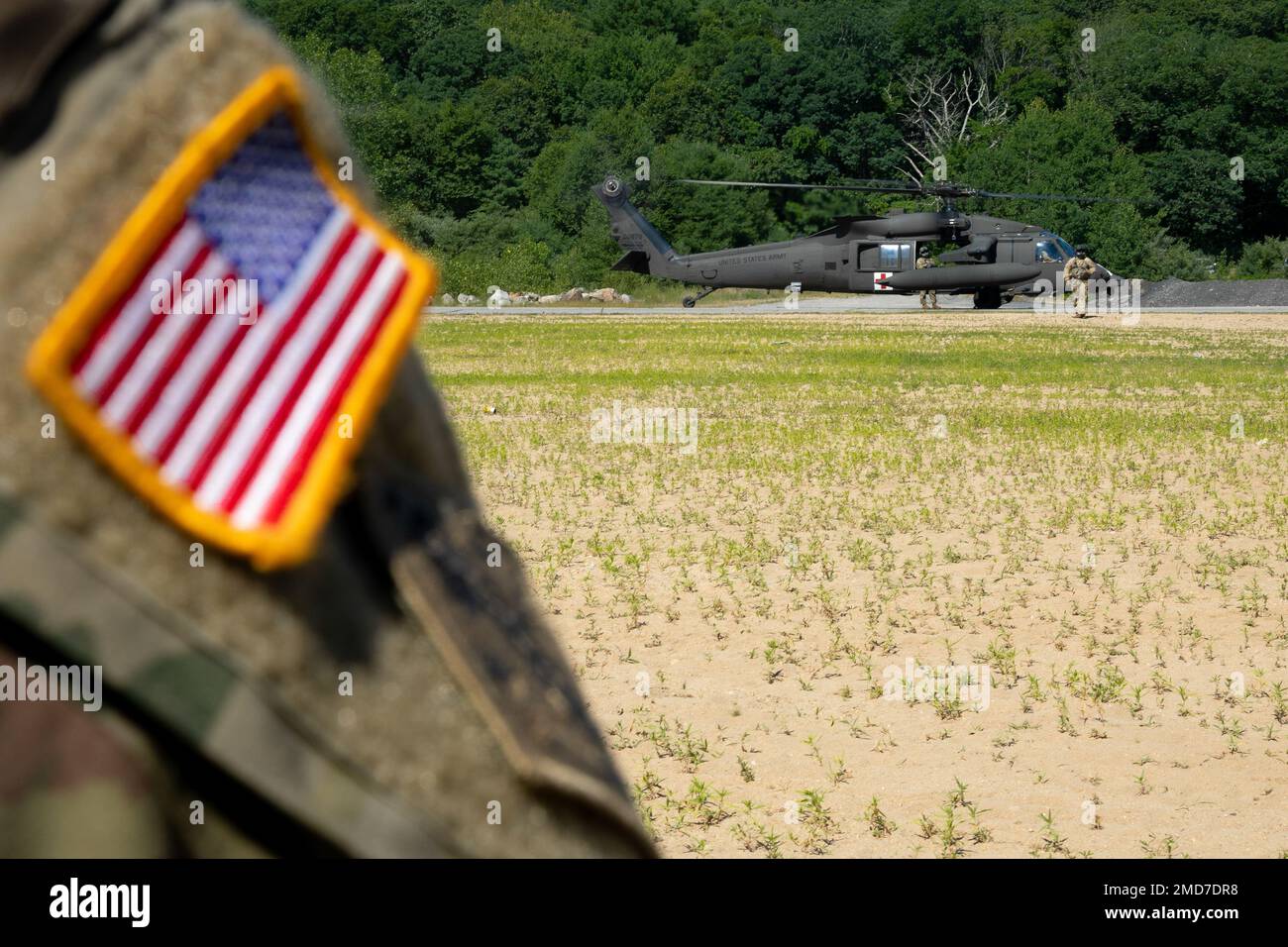 UN EE.UU El jefe de la tripulación del helicóptero HH-60M MEDEVAC (Evacuación Médica) del 3rd.º Batallón, 126th.º Regimiento de Aviación, de la Guardia Nacional del Ejército de Connecticut, se acerca a la estación de ayuda del batallón en la Reserva Militar Stones Ranch, East Lyme, Connecticut, el 13 de julio de 2022. Los soldados entrenados como parte del Curso de Transición de Medicina de Combate trabajaron junto a la tripulación de MEDEVAC y aprendieron a acercarse, cargar y descargar víctimas de la aeronave. Foto de stock