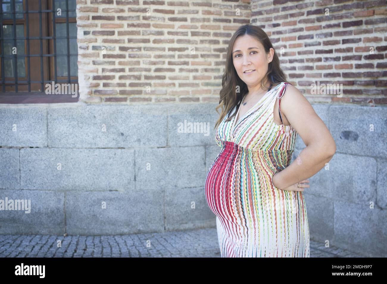 Agencia de viajes Mensajero histórico Mujer embarazada de siete meses al aire libre con vestido a rayas de varios  colores. Escena del día Fotografía de stock - Alamy