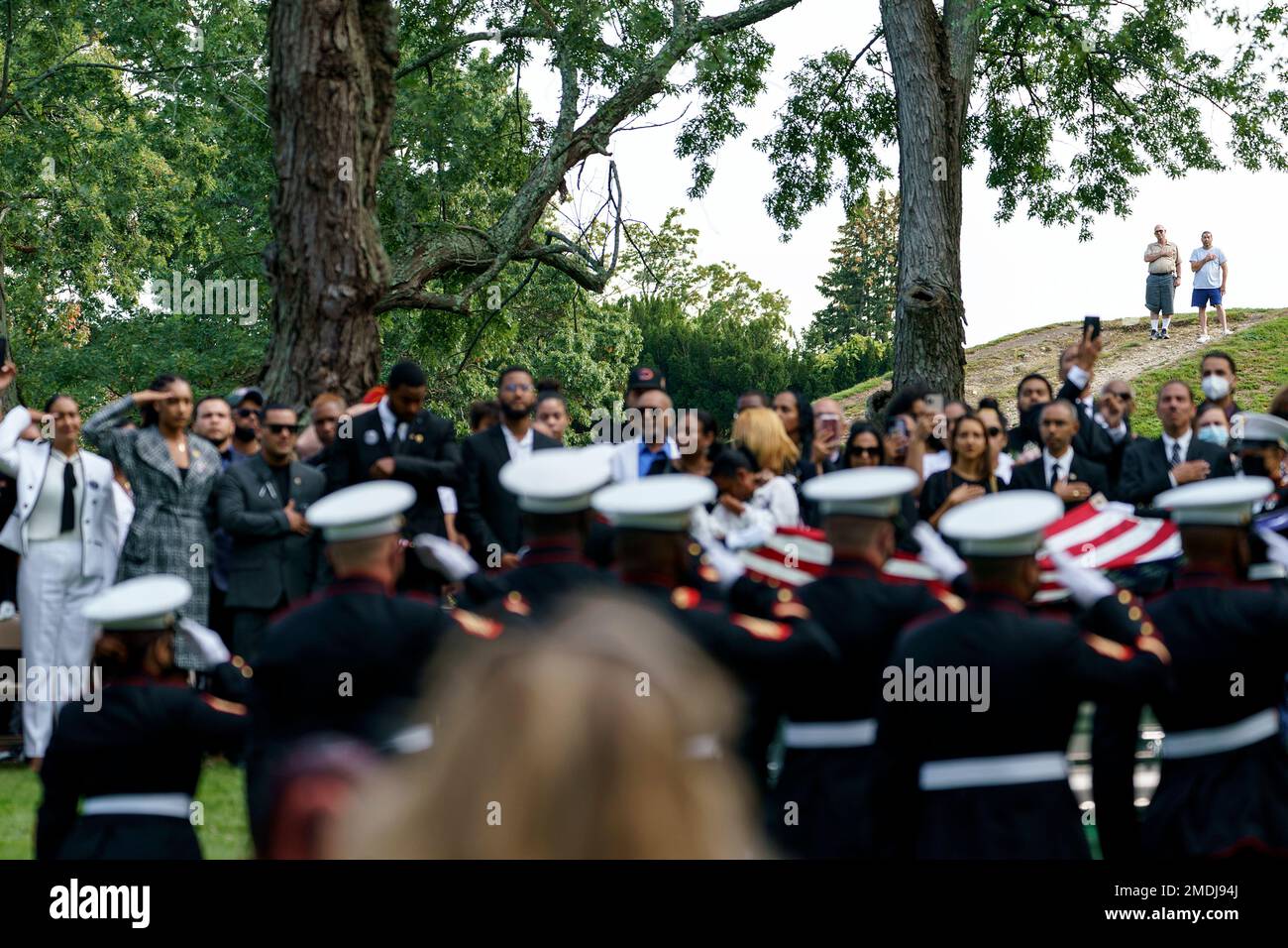 Members of the public watch from a hill as the American flag is folded ...