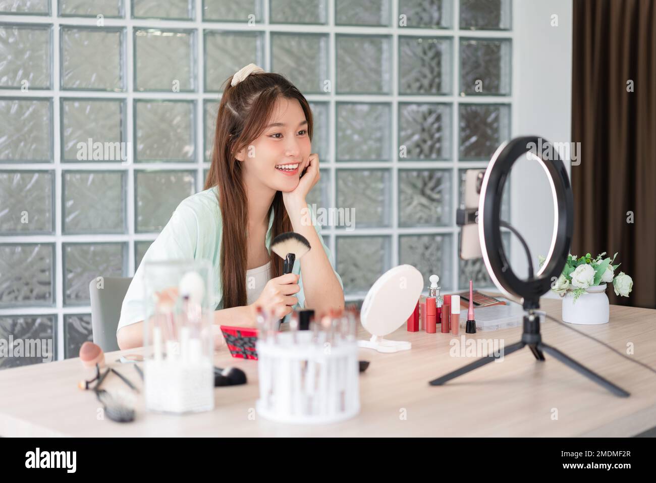 Beauty blogger concepto, la mujer joven introdujo el cepillo de maquillaje y cosméticos para grabar vídeo para Vlog. Foto de stock