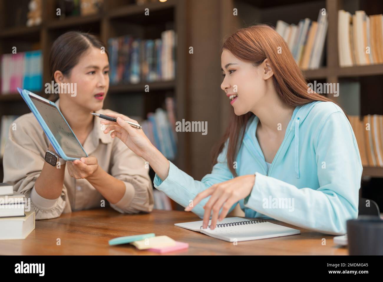 Concepto de la educación de la universidad, gráfico que señala de la muchacha adolescente en la tableta a hacer la pregunta con el profesor. Foto de stock