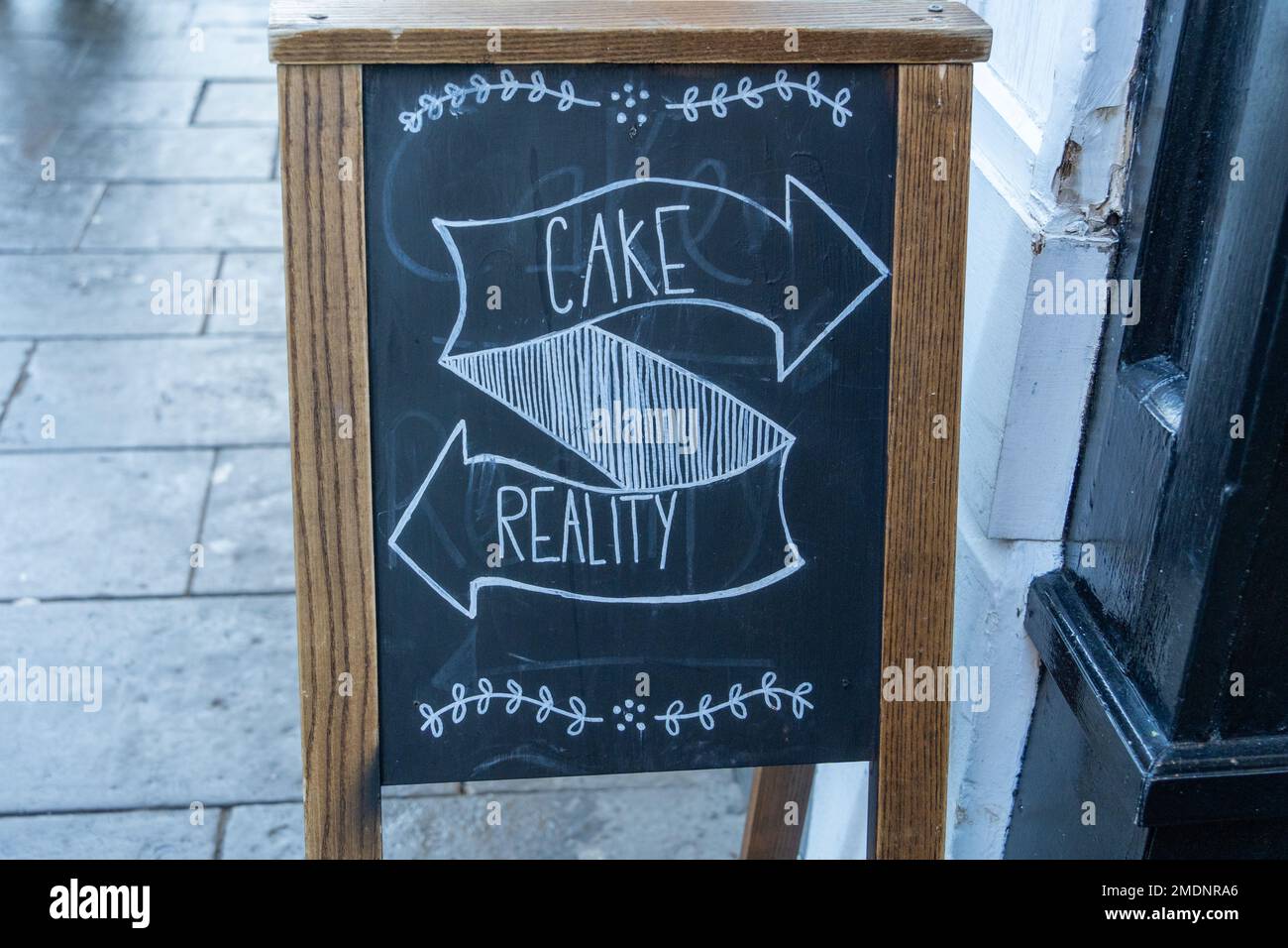 El popular letrero de pizarra que muestra las direcciones para el pastel y  la realidad fuera de un café en la ciudad de Durham, Reino Unido Fotografía  de stock - Alamy