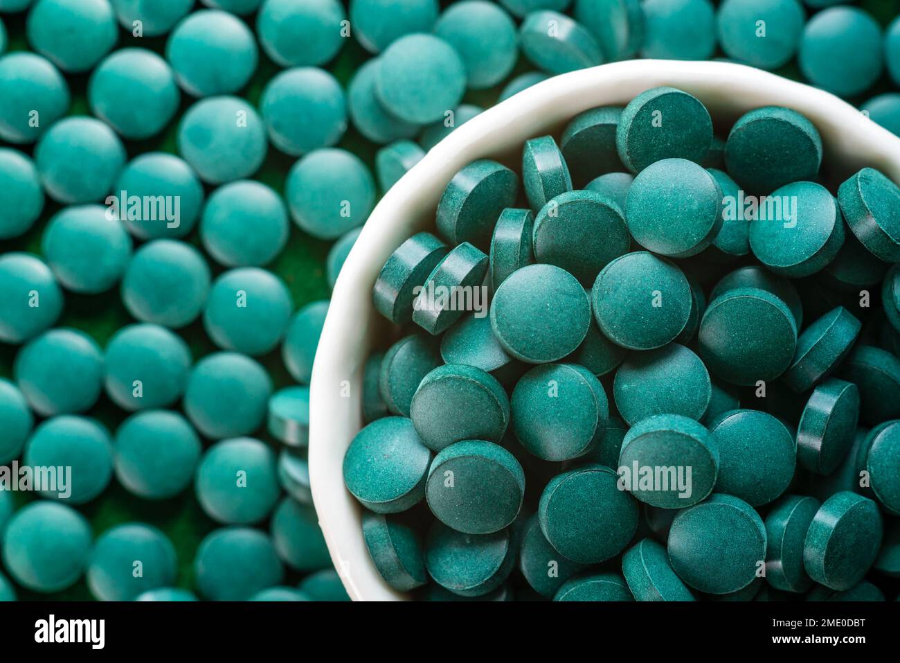 Espirulina orgánica verde en pastillas de algas pastillas cuchara de madera de bambú rica en hierro Primer plano Super concepto de comida saludable. Foto de stock