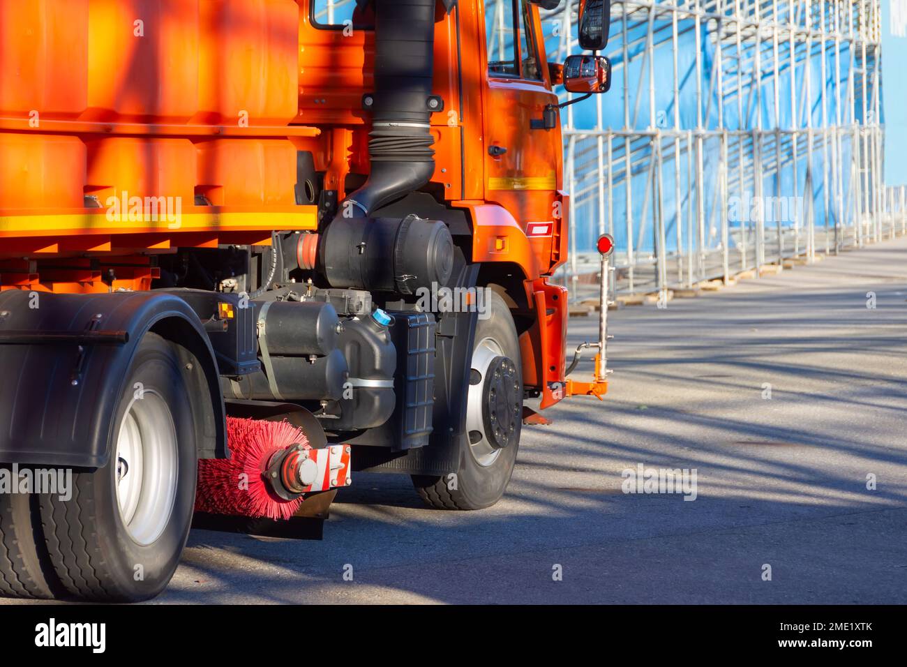 Camión de limpieza naranja con una aspiradora de cepillo para la limpieza de calles de la ciudad Foto de stock