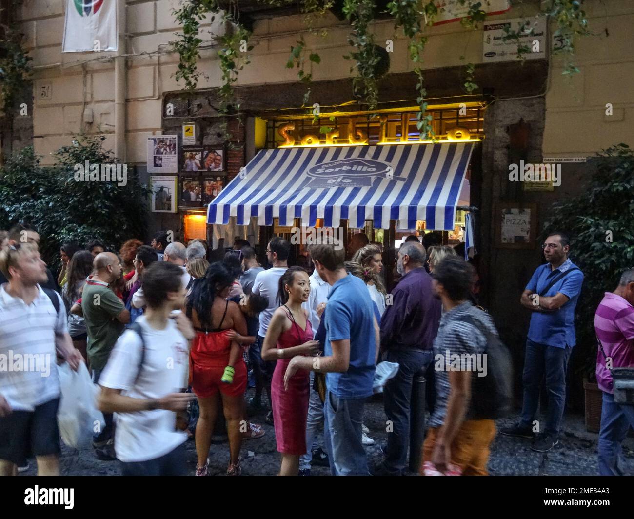 Multitud de hambrientos esperando una mesa fuera de la famosa Pizzeria Sorbillo de Naple, Italia. Foto de stock