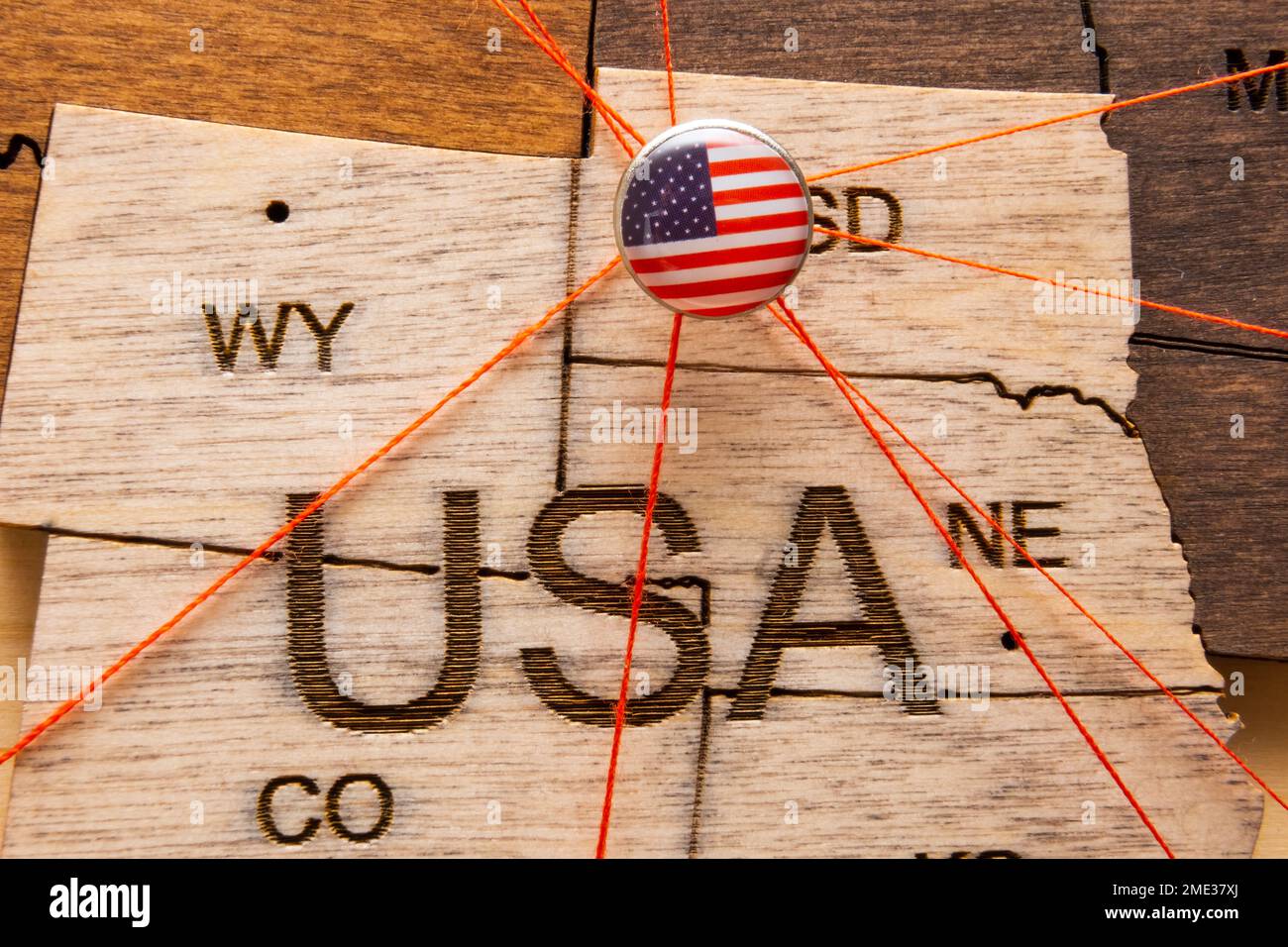 La bandera de EE.UU. En el pushpin con hilo rojo mostró los caminos de  movimiento o áreas de influencia en la economía global en el mapa de  madera. Planificación de viajes o