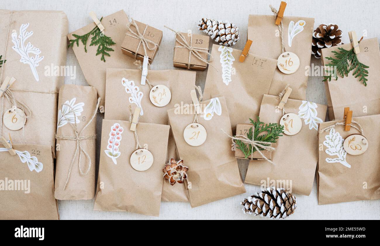 Bolsas de papel decoradas con conos de pino y cajas de cartón en