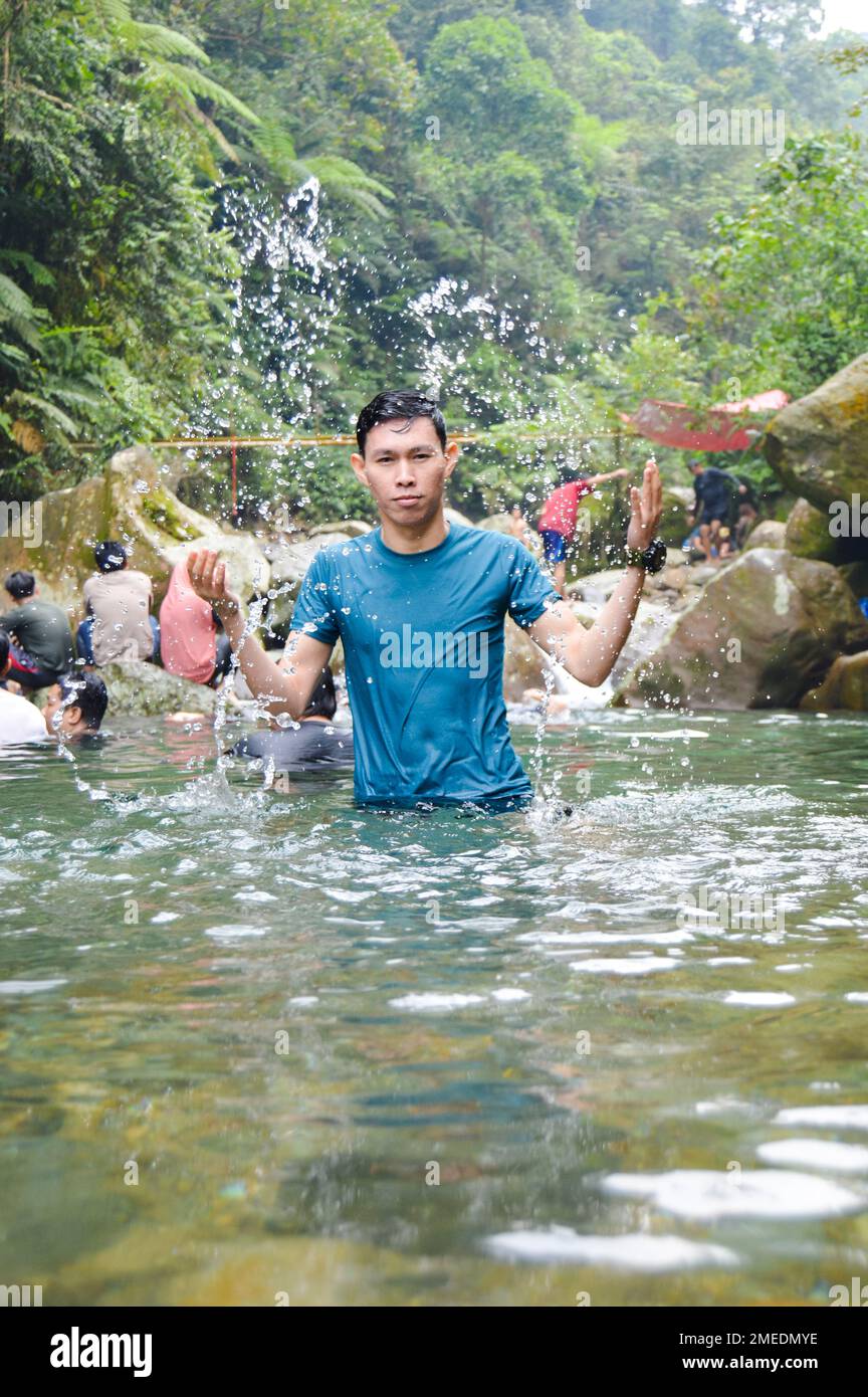 Nadar, jugar en el agua y disfrutar de la belleza natural del Curug Lembah Tepus, con enfoque seleccionado. Foto de stock