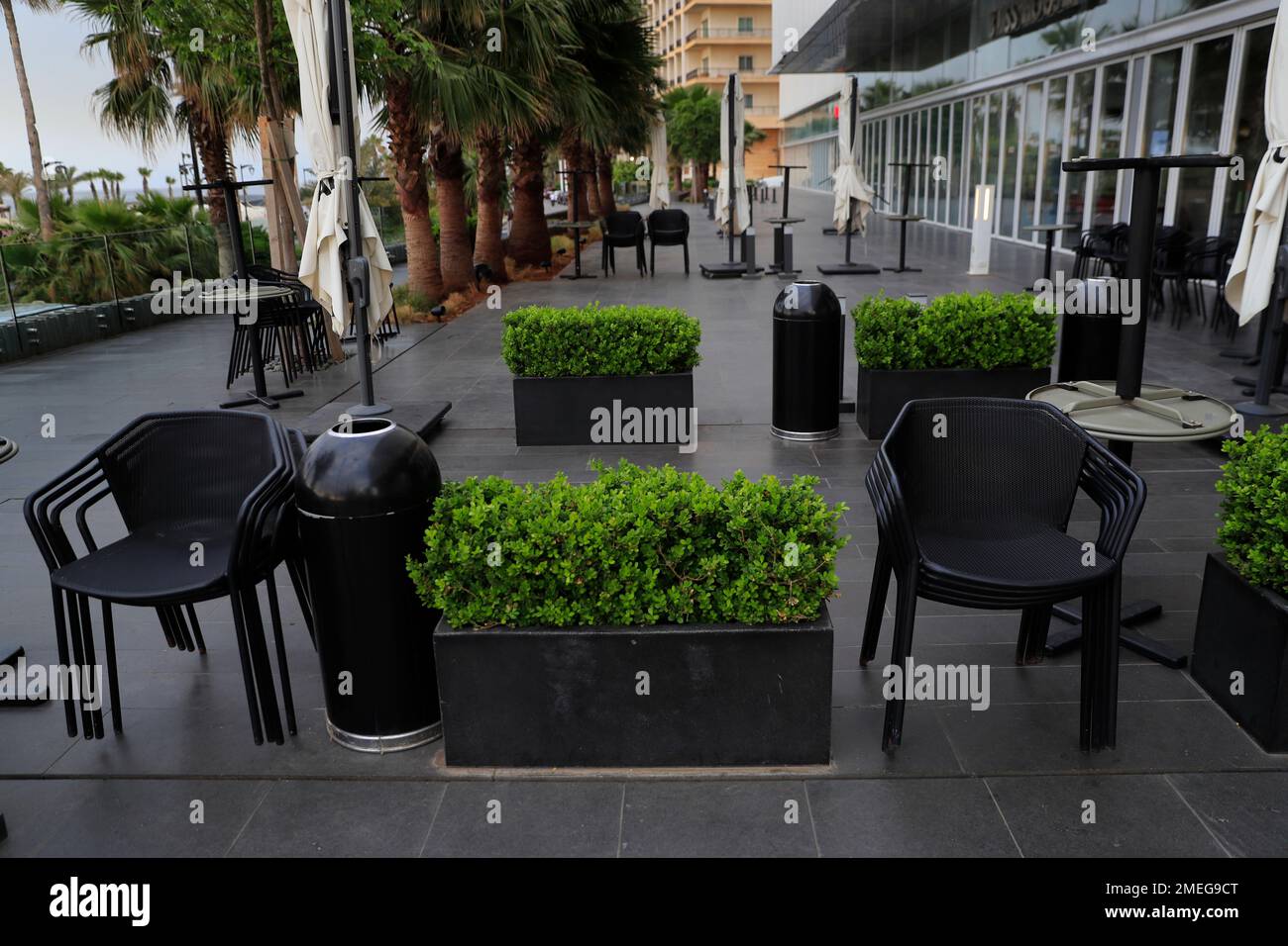 Assembled tables and chairs are empty at closed coffee shops at Beirut