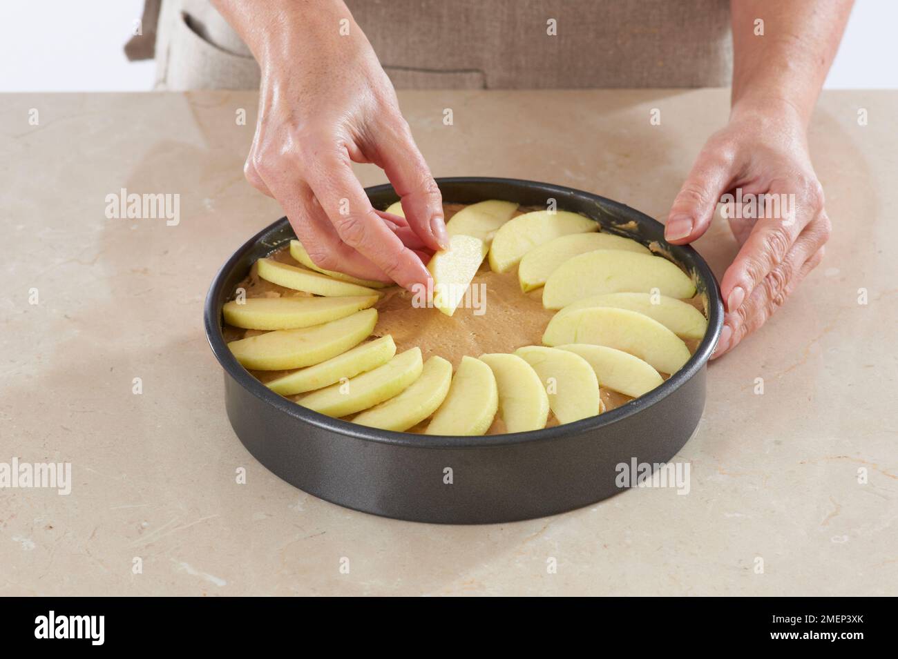 Hacer pastel de manzana alemán, organizando cuñas de manzana en la capa superior de masa Foto de stock