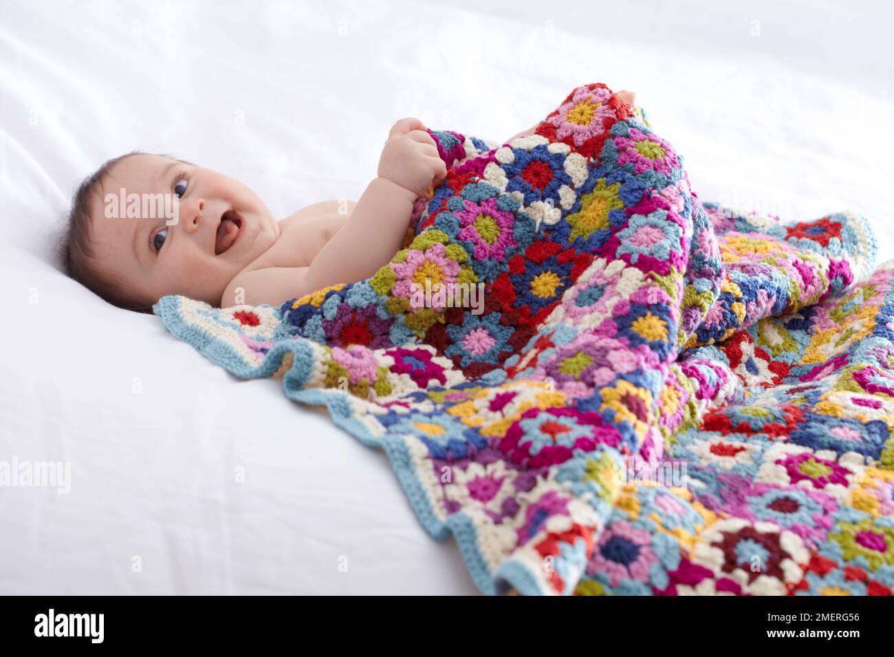 Bebé debajo de una manta de ganchillo bebé abuelita, 6,5 meses Foto de stock